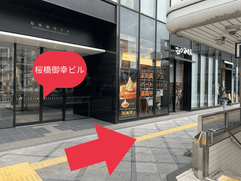 地上に上がると、1階にコメダ珈琲店が入っている{red}「桜橋御幸ビル」{/red}が見えます。{red}右手側（四ツ橋筋方面）{/red}に進んでください。
