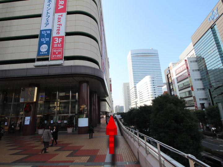 そごうの前まで来たら、ペデストリアンデッキ（空中歩道）のそごうの脇を直進してください。