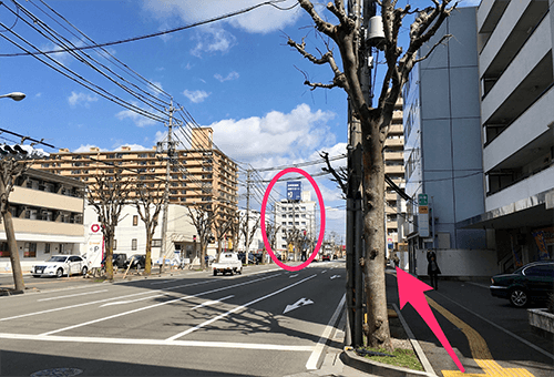 屋上に大きな紺色の看板があるビルに向かってそのまま直進して下さい。