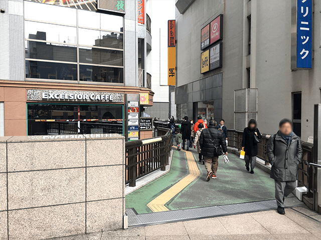 {red}「伊勢丹」{/red}横の道を直進して、{red}「Excersror CAFE」{/red}の看板横を直進してください。