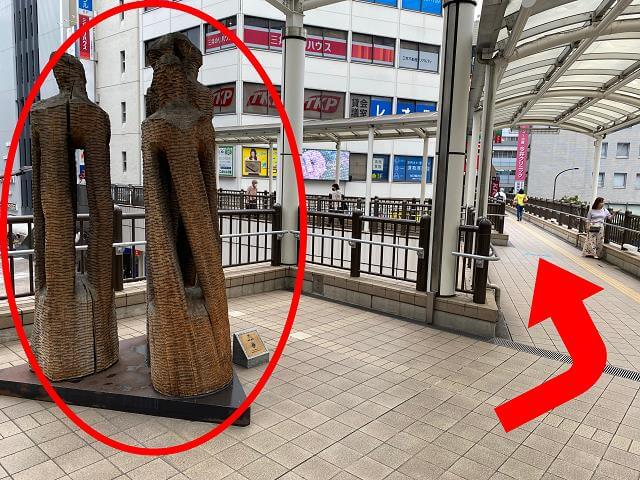 北口{red}ペストリアンデッキの木の彫刻{/red}を{red}右{/red}に曲がります。