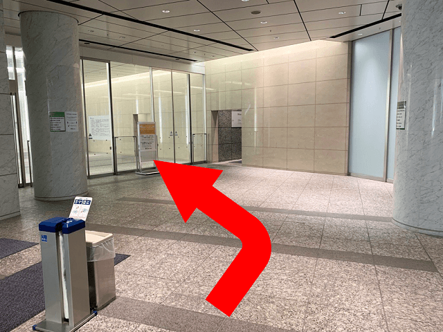 エスカレーターを降りると、マークワンビルエントランスがあります。
エントランスに入り、{red}左手のエレベーターホール{/red}へ進んでください。