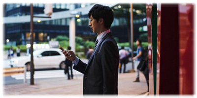 携帯を見ている30代男性