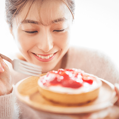 ケーキを食べて笑顔の女性